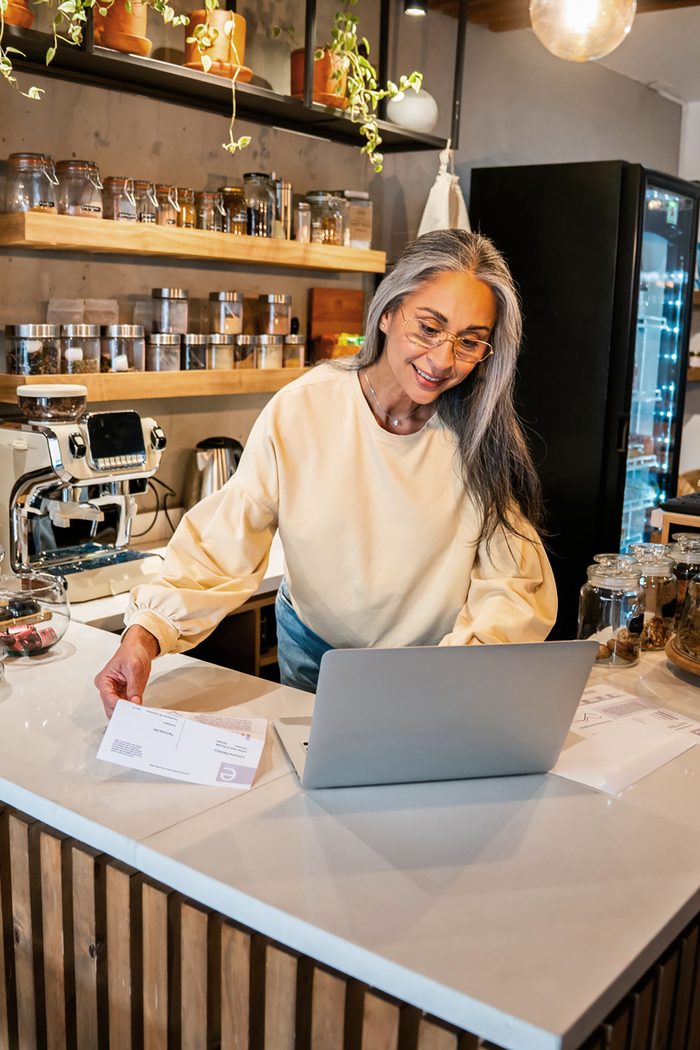 How to apply for a Cardiff business credit card: a café owner applying on a laptop at her counter