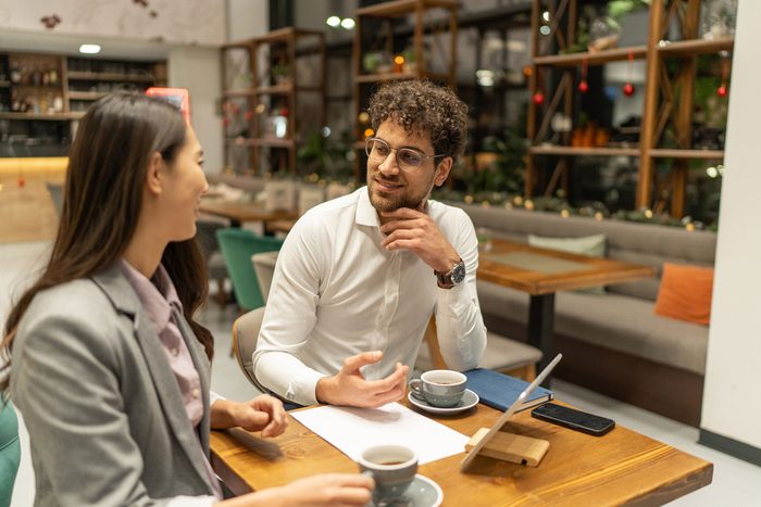 Two people talking over coffee at a café table