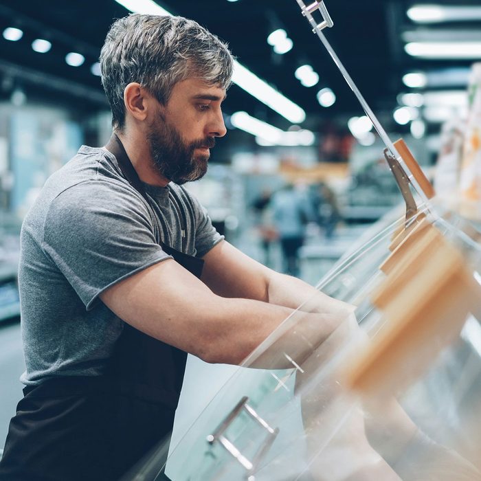 Small business equipment financing: a shop worker restocking a refrigerated display case
