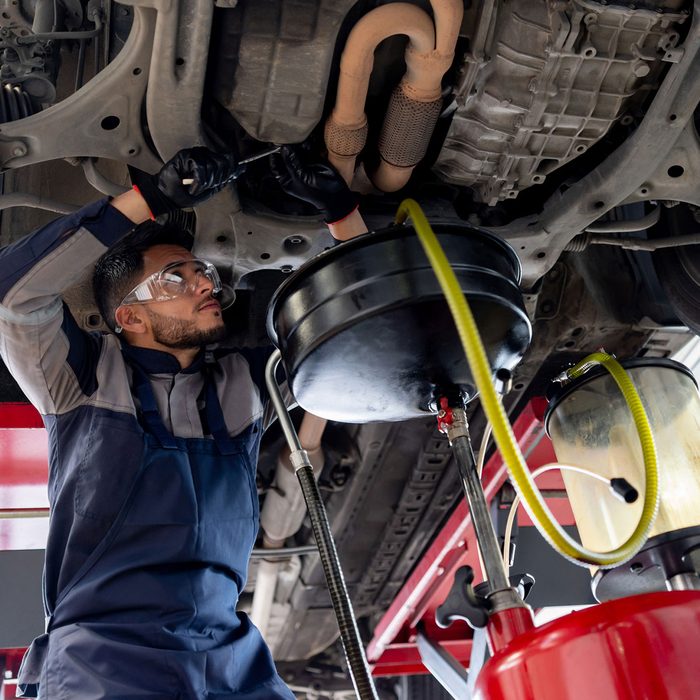 A mechanic working under a car raised on a lift
