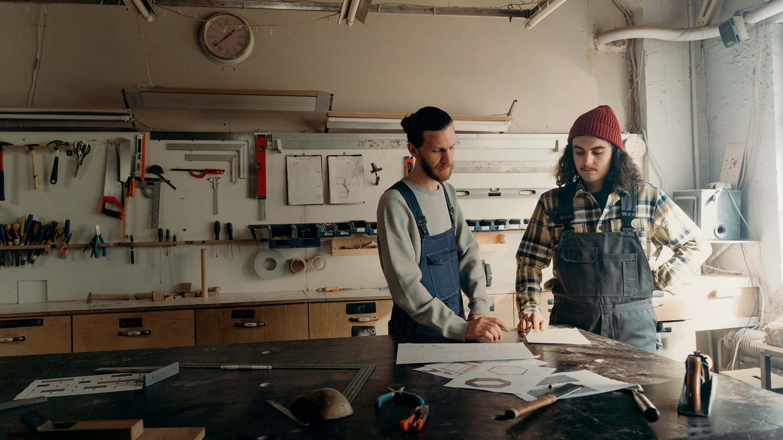 Business revolving line of credit: two woodworkers planning a job over drawings at their workshop bench