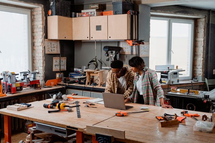Instant business line of credit: two shop owners going over figures on a laptop at their workbench