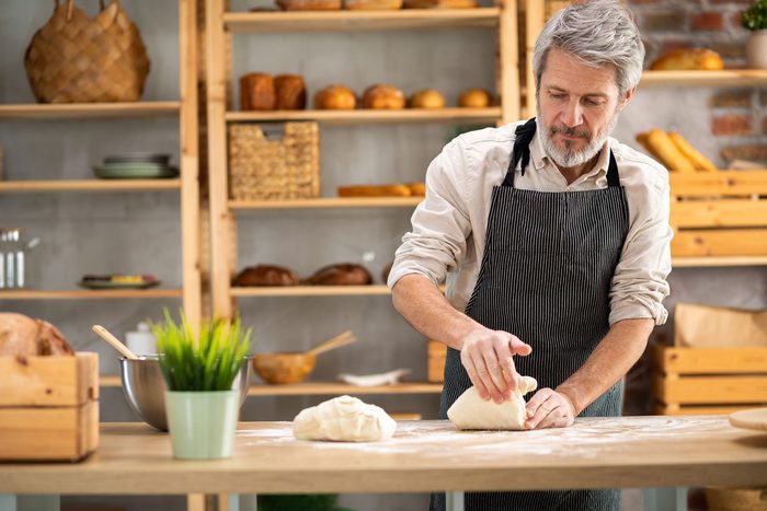 Cash advance for business owners: a baker kneading dough at the counter of his bakery