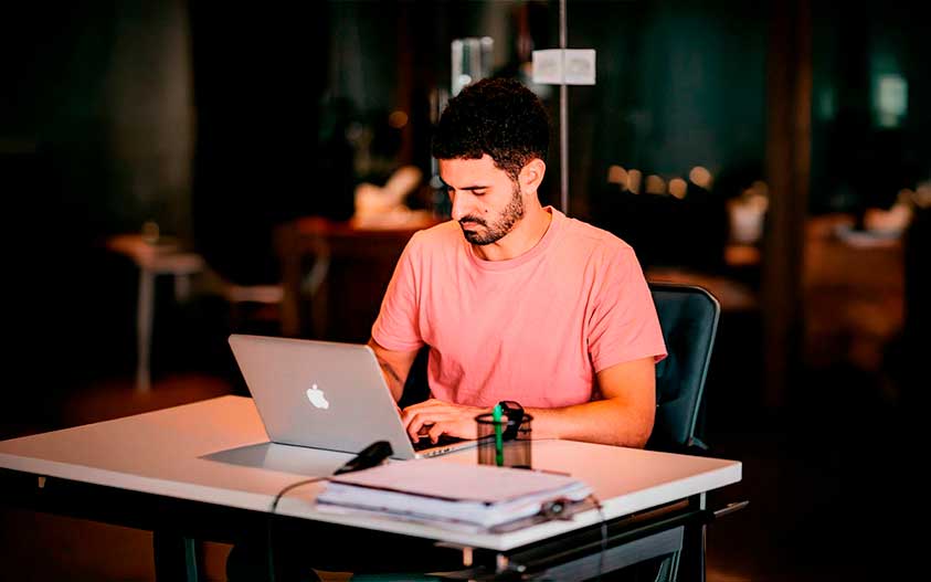 A Cardiff team member working at a laptop at a desk in a quiet workspace.